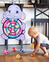Child playing with a dartboard shaped like an elephant.