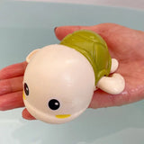 Toy turtle with a green shell held in a hand against a light blue background