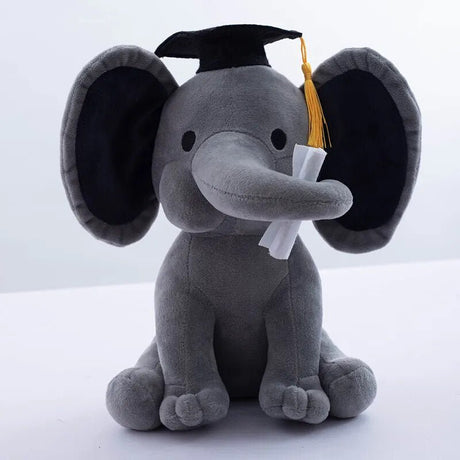 Gray plush elephant toy wearing a graduation cap and tassel on a white background