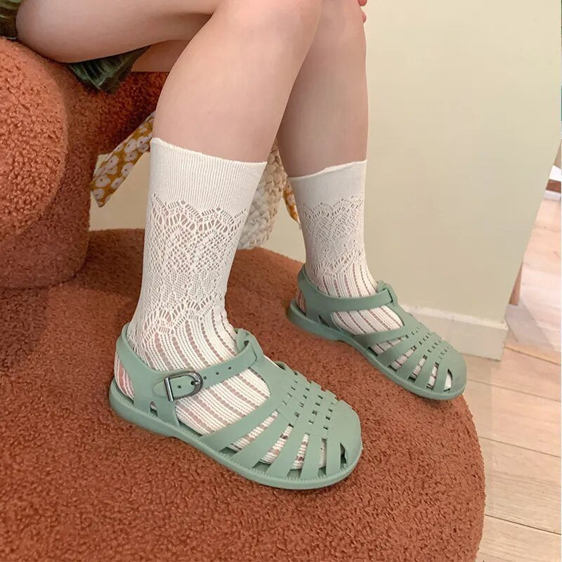 Person wearing green sandals and white socks.