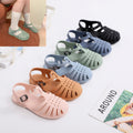 Colorful children's sandals displayed on a white surface 