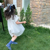 Child in a white dress and blue shoes 