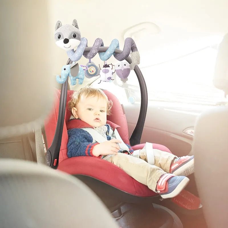 Child in a car seat with a fox spiral hanging toy for entertainment during car rides.