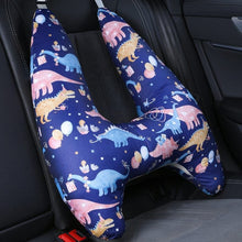 U-shaped travel pillow with dinosaur pattern on a car seat