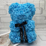 Blue rose teddy bear with a black ribbon.