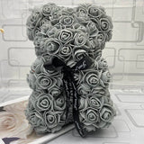 Gray rose teddy bear with a black ribbon.