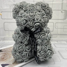 Gray rose teddy bear with a black ribbon.