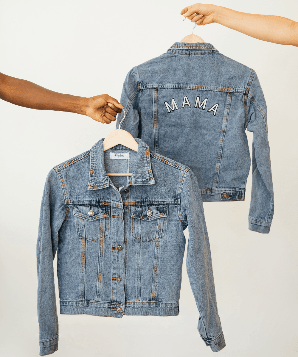 Two denim jackets, one with 'MAMA' embroidered on the back, on hangers 