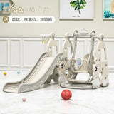 Children's playground slide and swing set with basketball on a light-colored floor.