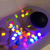 Child playing with colorful light-up toys in a bathtub