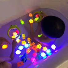 Child playing with colorful light-up toys in a bathtub