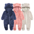 Three baby onesies with bear ears in blue, pink, and gray