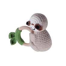 Crochet Sloth Rattle and Teether plush toy holding a green leaf for nursery decor and crib toy display.