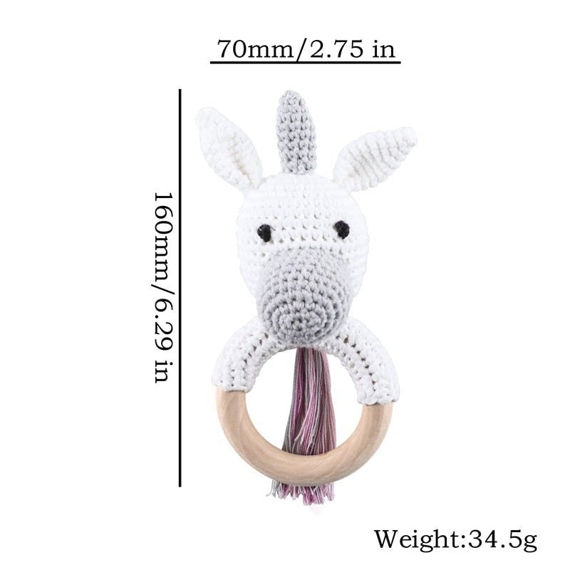 Crochet Unicorn Rattle and Teether plush toy with wooden ring for grasping practice and early motor skill development.