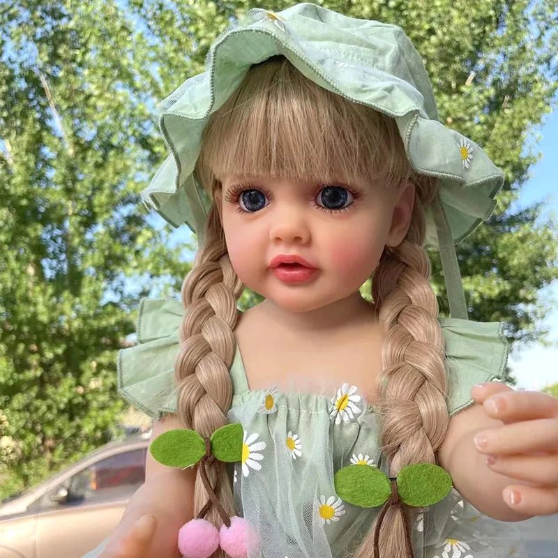 Curly hair waterproof Reborn Doll with silicone body in a green floral outfit and hat for outdoor play and gifting.