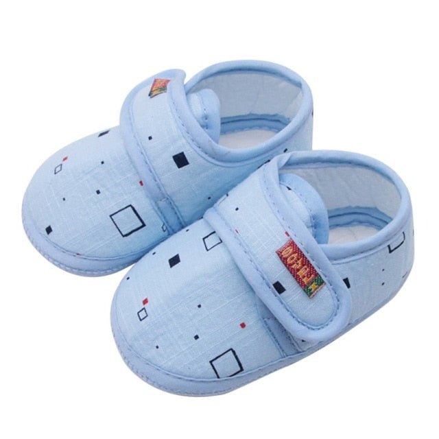 Pair of light blue baby shoes with colorful designs 