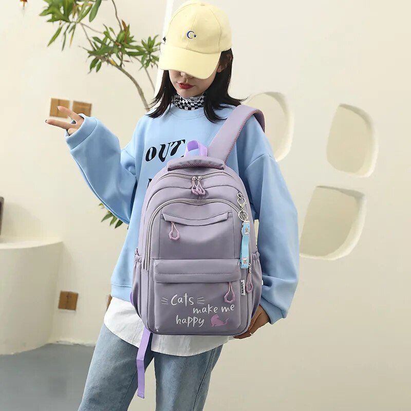 Person wearing a light blue sweatshirt and yellow cap with a purple backpack.