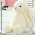 White plush bunny toy with measurement.