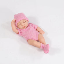 Sleeping baby doll in a pink outfit and hat
