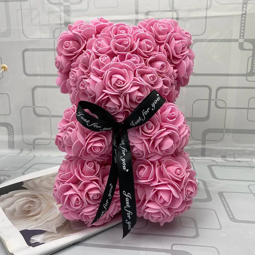 Pink rose teddy bear with a black ribbon.