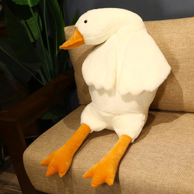 Plush duck toy on a brown chair with a plant in the background