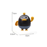 Small black and yellow penguin figurine with measurements on a white background