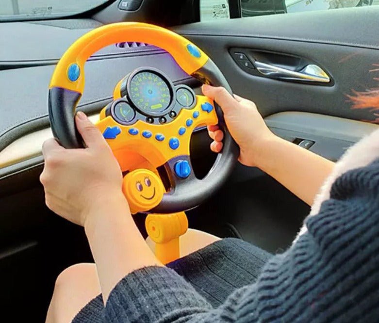 Child playing with a toy steering wheel inside a car