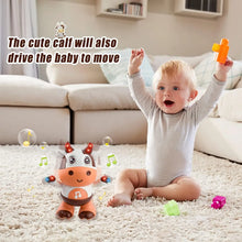 Baby with arms raised on a rug while the dancing cow toy plays with music notes