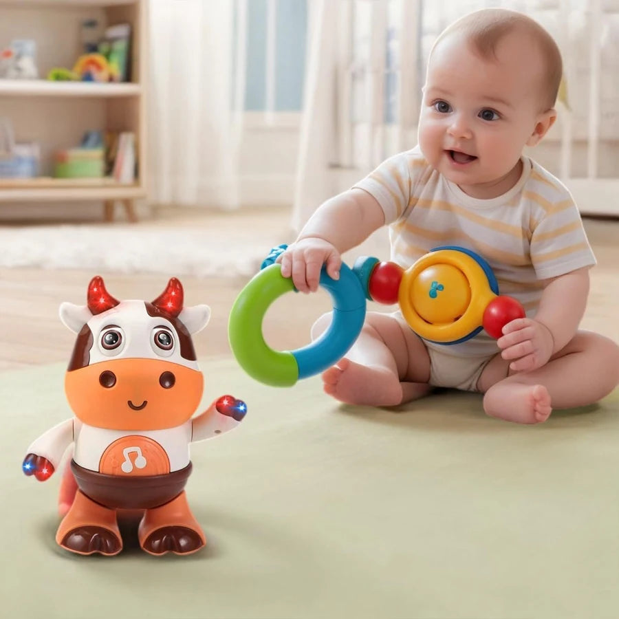 Dancing cow toy on a play mat while a baby holds a colorful ring toy