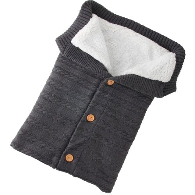 Dark grey knitted baby sleeping bag in a cosy sleep sack style for winter nights and pram naps.