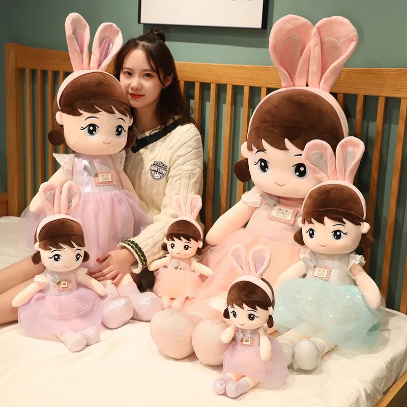 Woman with a collection of plush toys resembling children with bunny ears on a bed.