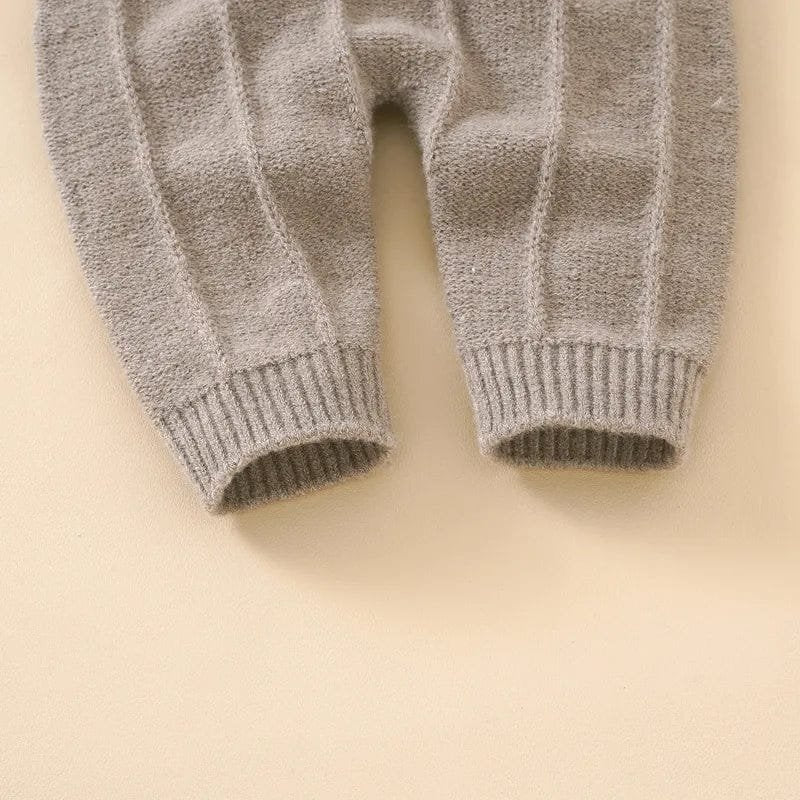 Close-up of gray knitted baby pants on a beige background