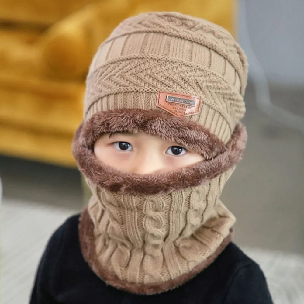 Person wearing a beige knitted hat and scarf with a blurred background