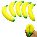 Set of yellow banana-shaped stress relievers with green tips on a white background.
