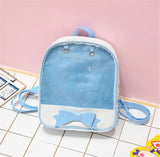 Small blue backpack with a bow on a tiled floor against a pink wall