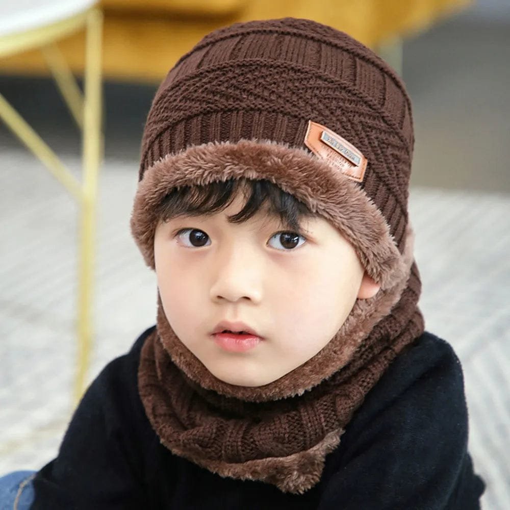 Child wearing a brown knitted hat and scarf set with a blurred background