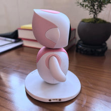 Side view of a pink and white desktop robot pet on a round base with small contact pins at the bottom edge
