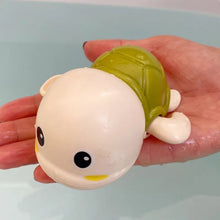 Duck and Penguin Egg Water Spray Bath Toy green turtle design held for tub time water fun.