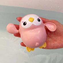 Duck and Penguin Egg Water Spray Bath Toy pink cartoon bird design held for bath time entertainment.
