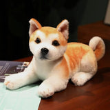 Stuffed dog toy resembling a Shiba Inu on a wooden surface