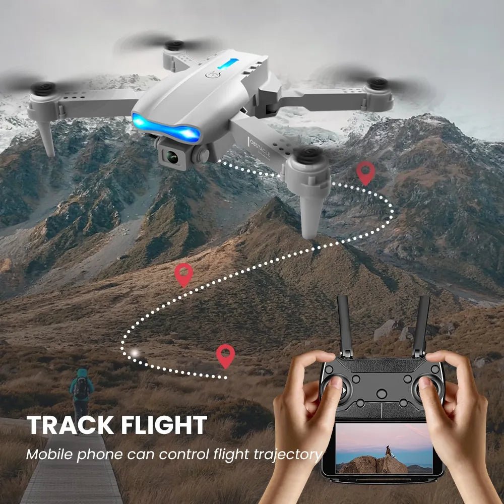 E99 K3 Pro drone flying over mountain terrain controlled by smartphone app for aerial photography.