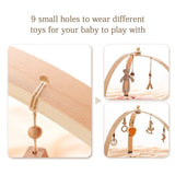 Wooden baby mobile with small holes for toys, showing assembly and use.