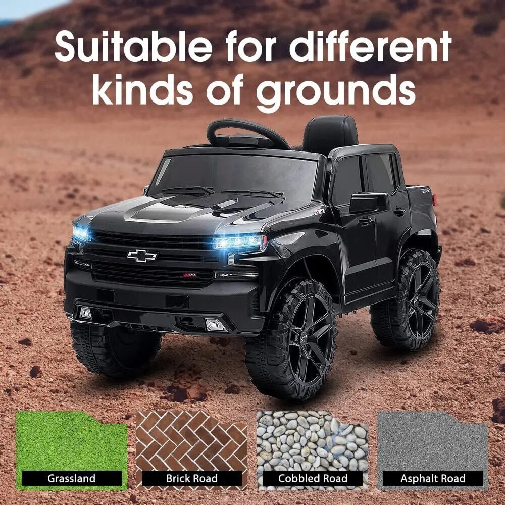 Black toy truck on a dirt surface with text 'Suitable for different kinds of grounds' and road types below.