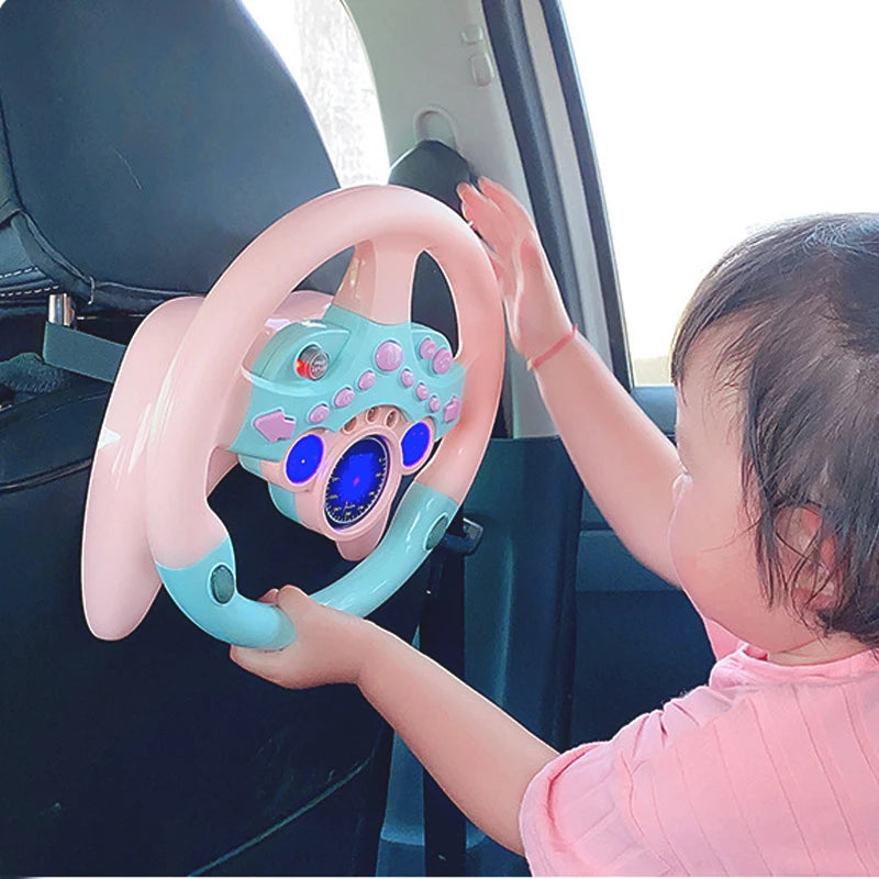 Toddler girl reaching for a pink steering wheel toy fastened inside a car