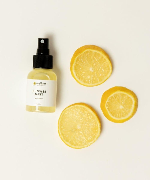 Morning shower mist spray bottle shown with fresh lemon slices for an energizing citrus aromatherapy routine.