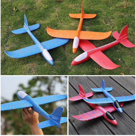 Colorful foam glider planes on grass and a wooden surface with a hand holding one.