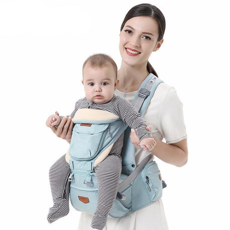 Woman holding a baby in a blue baby carrier.