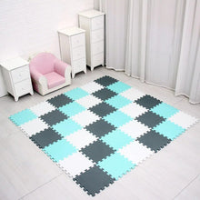 Checkered foam puzzle mat on a floor with white furniture and pink chair.