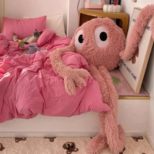 Huge 175cm green alien plush monster doll with extended limbs resting on pink bedding for cozy naps.