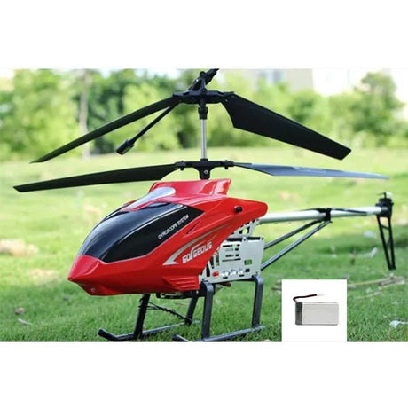 Red and black helicopter on grass with a small inset of a battery pack.